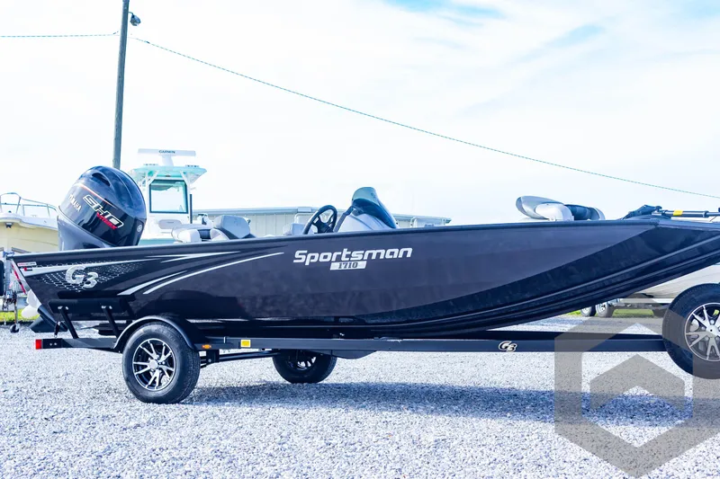 Slide: The Image of 2025 G3 Sportsman 1710 boat on trailer, sleek black design, outdoor setting. - 15