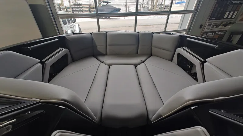 Slide: The Image of 2025 Moomba Max boat interior with spacious, cushioned seating in a showroom. - 9