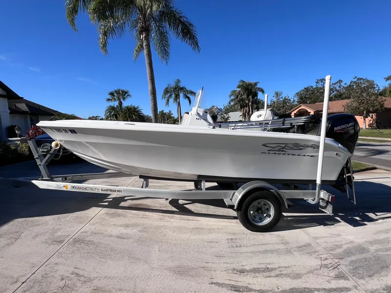 Slide: The Image of 2021 Glasstream 180 CC boat on trailer, Mercury 115 engine, palm trees in background. - 6