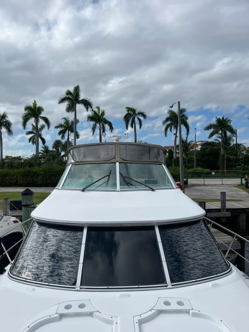 Slide: The Image of 2001 Cruisers Yachts 4450 Express Motoryacht docked with palm trees in background. - 21