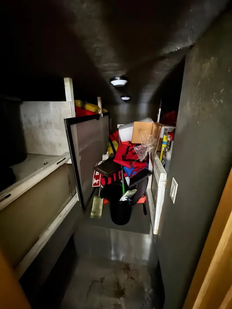 Slide: The Image of Storage area inside 2000 Bluewater Yachts 5200 Millenium, filled with various items and equipment. - 11