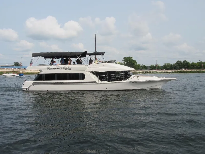 Slide: The Image of 2000 Bluewater Yachts 5200 Millenium cruising on a calm lake under a cloudy sky. - 2