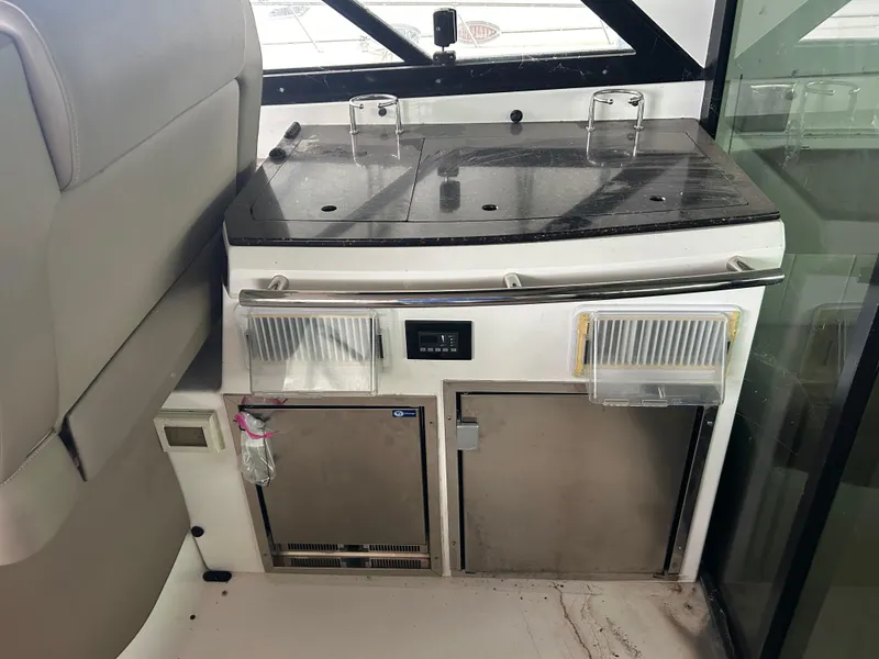 Slide: The Image of 2014 Regal 44 Sport Coupe interior kitchenette with countertop and storage. - 15