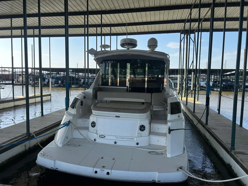 Slide: The Image of 2014 Regal 44 Sport Coupe docked in a marina under a covered structure. - 2