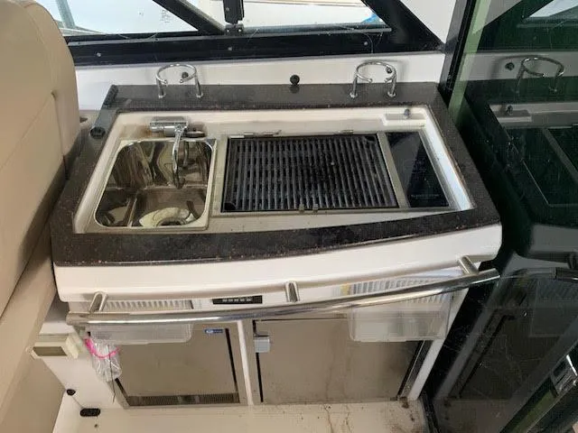 Slide: The Image of Outdoor kitchen on a 2014 Regal 44 Sport Coupe yacht with sink and grill. - 27