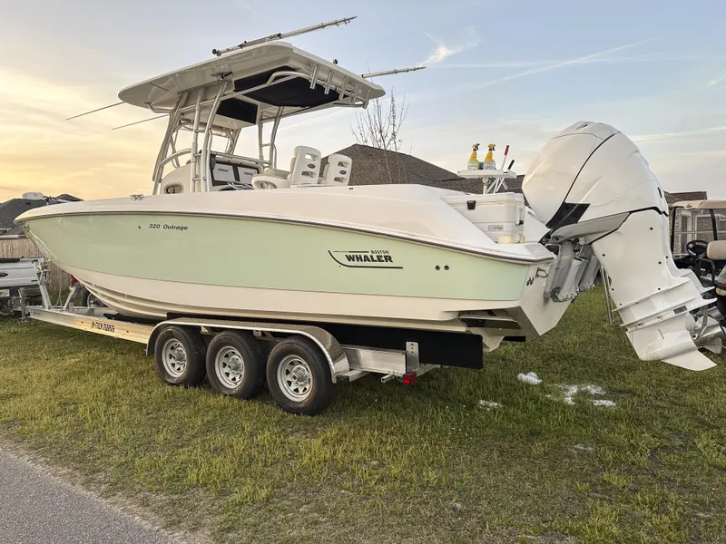 Slide: The Image of 2004 Boston Whaler 32 Outrage boat on a trailer, parked on grass. - 10