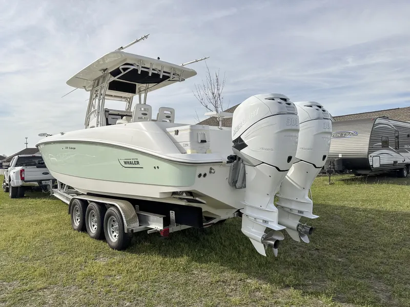 Slide: The Image of 2004 Boston Whaler 32 Outrage boat on trailer with twin engines, parked on grass. - 11