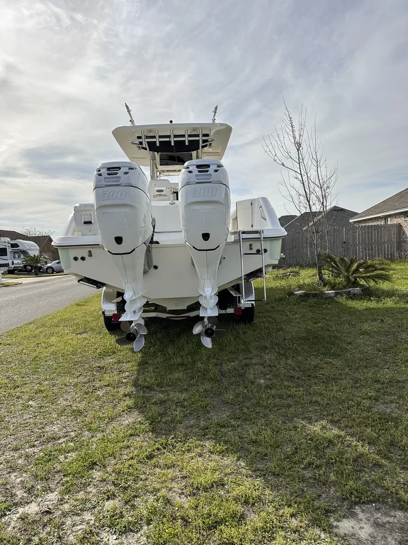 Slide: The Image of 2004 Boston Whaler 32 Outrage boat with dual outboard motors on grassy area. - 13