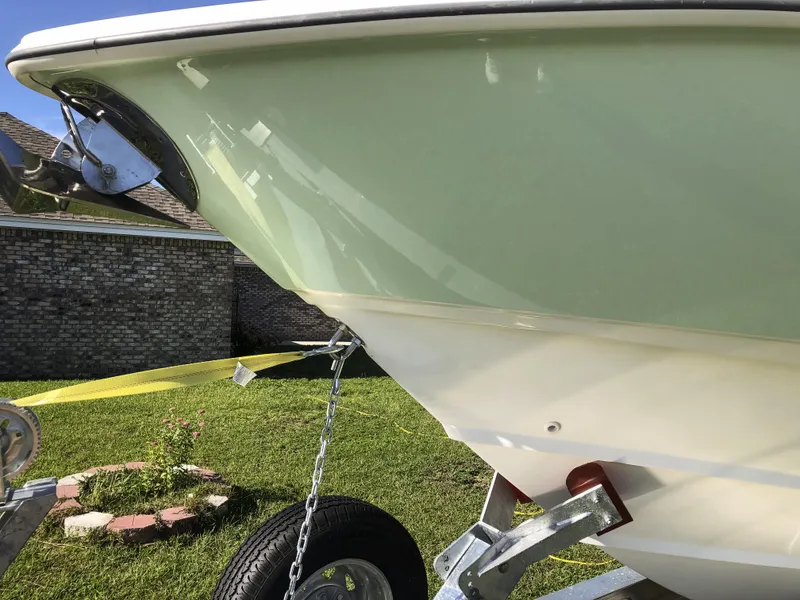 Slide: The Image of 2004 Boston Whaler 32 Outrage boat on trailer, parked on grass. - 15