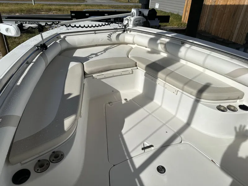 Slide: The Image of 2004 Boston Whaler 32 Outrage boat interior with cushioned seating and fishing rod holders. - 27