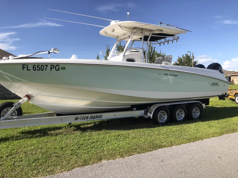 Slide: The Image of 2004 Boston Whaler 32 Outrage boat on trailer, parked on grass. - 7