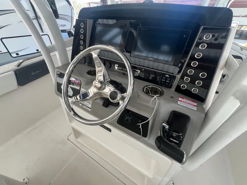 Slide: The Image of 2019 Robalo R242 Explorer boat dashboard with steering wheel and control panel. - 11