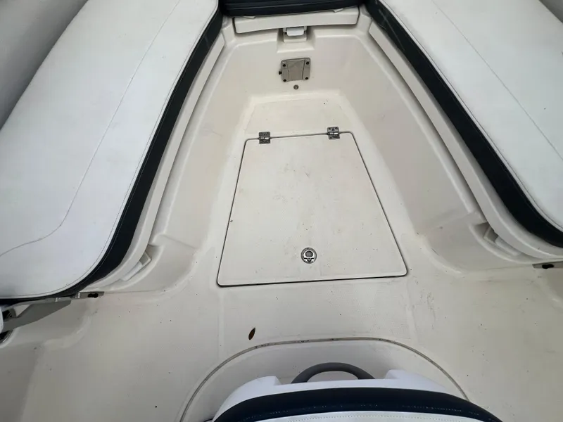 Slide: The Image of 2019 Robalo R242 Explorer boat interior with white seating and storage compartment. - 16