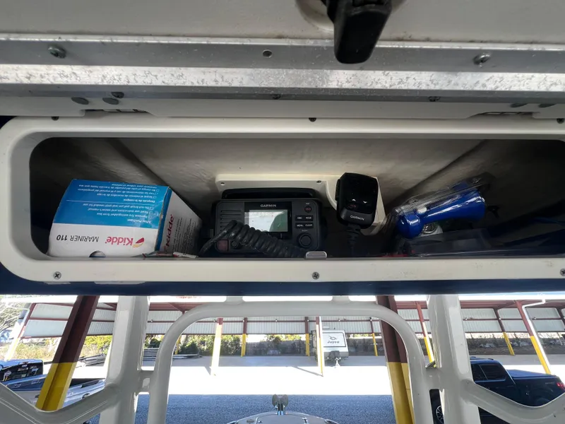 Slide: The Image of Storage compartment in 2019 Robalo R242 Explorer boat with radio and supplies. - 25