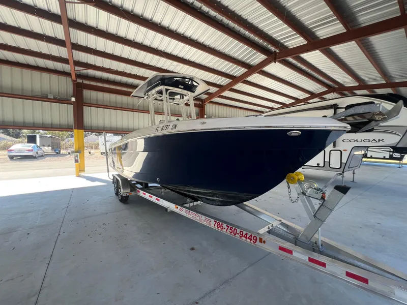 Slide: The Image of 2019 Robalo R242 Explorer boat on trailer under metal roof. - 5