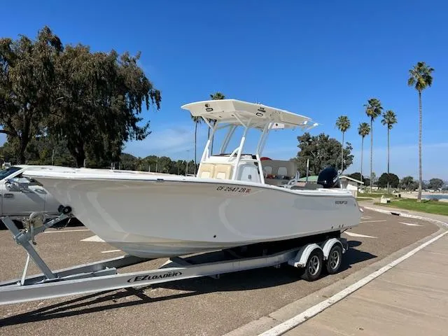Slide: The Image of 2018 Sea Fox 248 Commander boat on trailer, parked near palm trees and clear blue sky. - 18