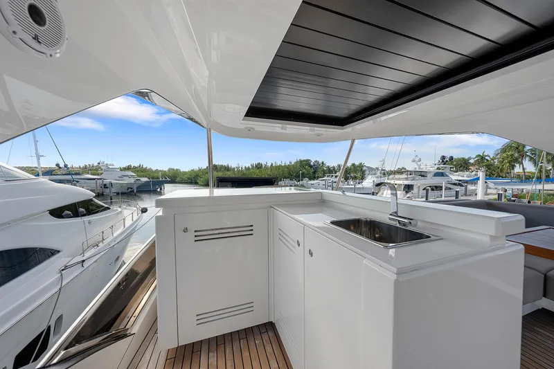Slide: The Image of Astondoa 66 yacht 2022, featuring sleek outdoor kitchen and scenic marina view. - 33