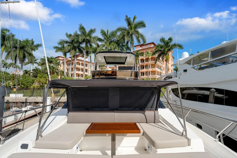 Slide: The Image of Astondoa 66 yacht, 2022 model, docked with palm trees and buildings in the background. - 45