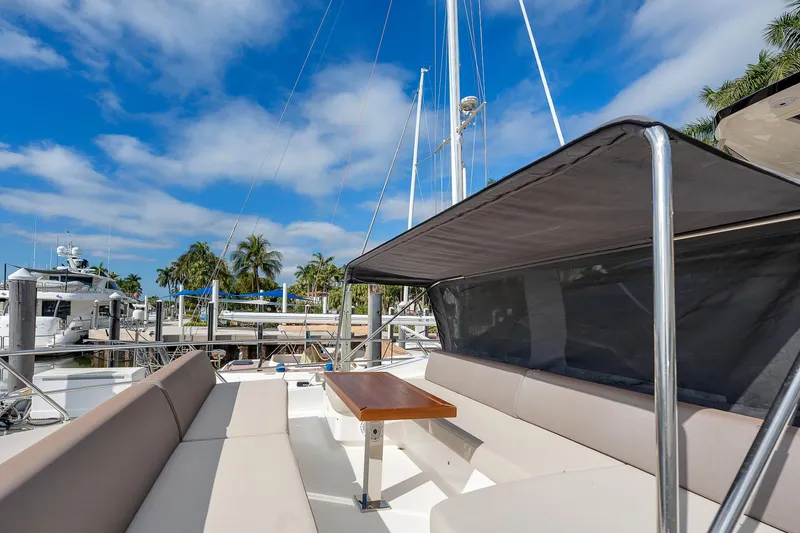 Slide: The Image of Astondoa 66 yacht 2022, featuring spacious deck seating under a canopy, docked at marina. - 46