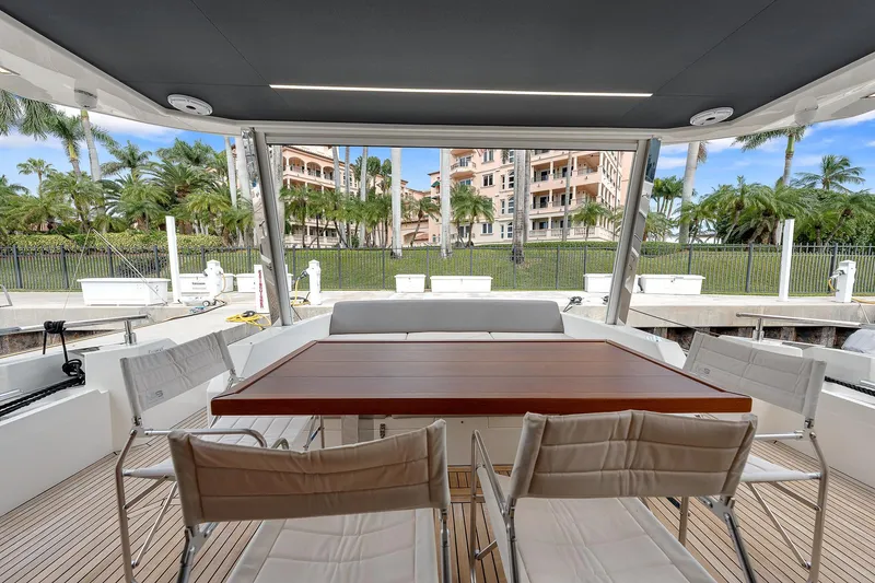 Slide: The Image of Astondoa 66 yacht 2022, elegant outdoor dining area with wooden table and chairs. - 49