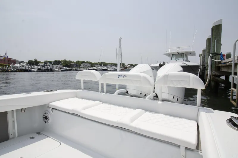 Slide: The Image of 2025 Yellowfin 26 Hybrid boat docked at marina, featuring spacious seating and twin engines. - 13