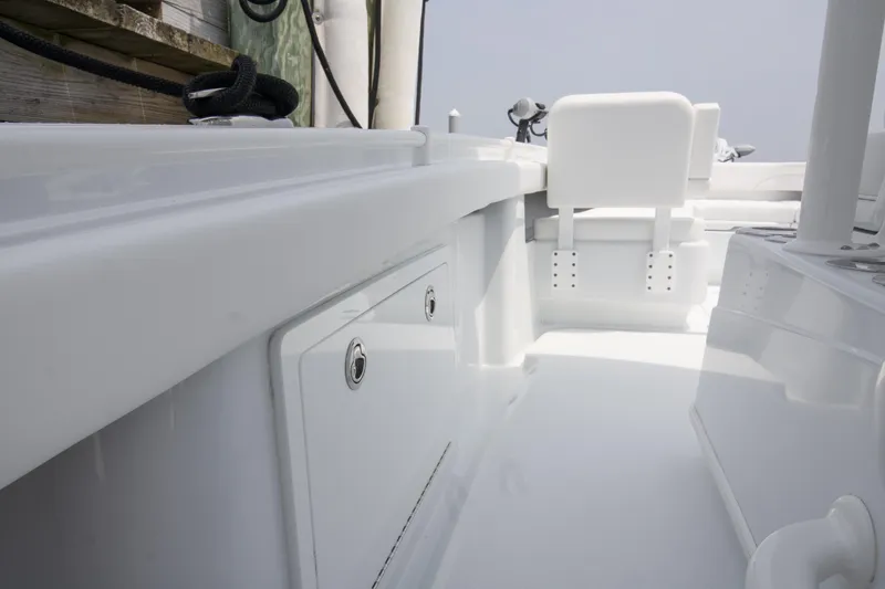Slide: The Image of 2025 Yellowfin 26 Hybrid boat interior, showcasing sleek white design and storage compartments. - 16