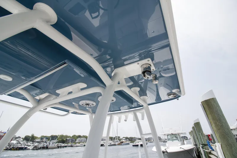 Slide: The Image of 2025 Yellowfin 26 Hybrid boat canopy with blue underside, docked at marina. - 23