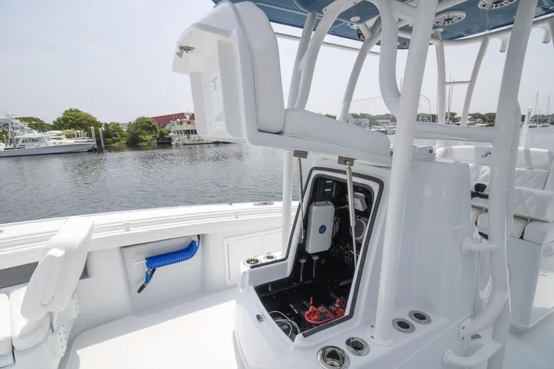 Slide: The Image of 2025 Yellowfin 26 Hybrid boat interior with open storage compartment, docked by the water. - 3