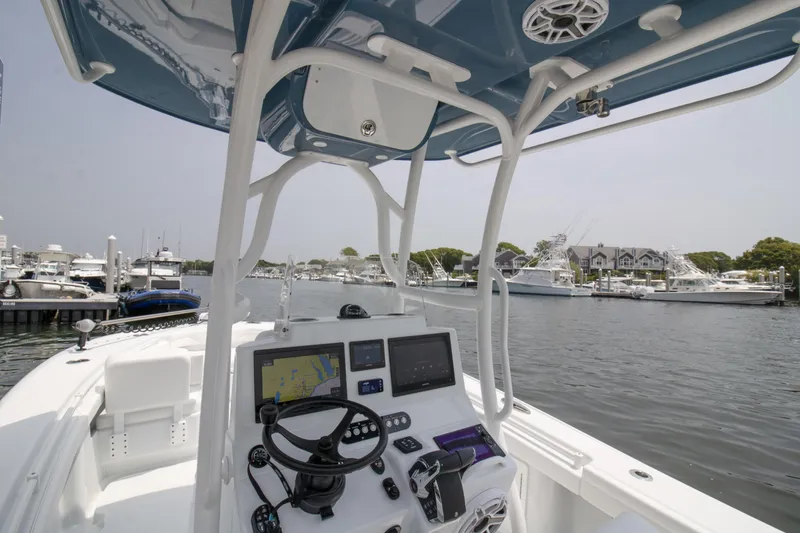 Slide: The Image of 2025 Yellowfin 26 Hybrid boat interior with navigation equipment, docked at a marina. - 5