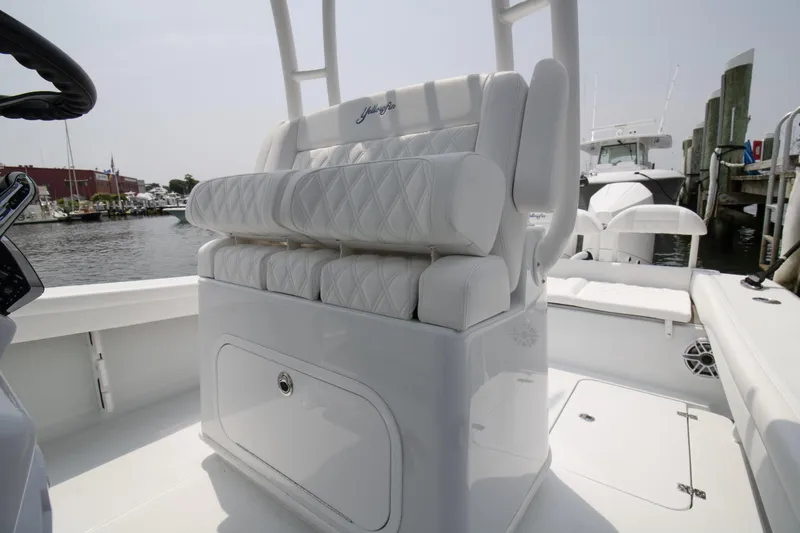 Slide: The Image of 2025 Yellowfin 26 Hybrid boat with white cushioned seating, docked at a marina. - 8