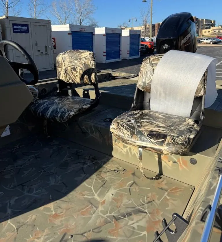 Slide: The Image of 2025 Tracker Grizzly 1754 SC boat with camouflage seats and steering wheel. - 32