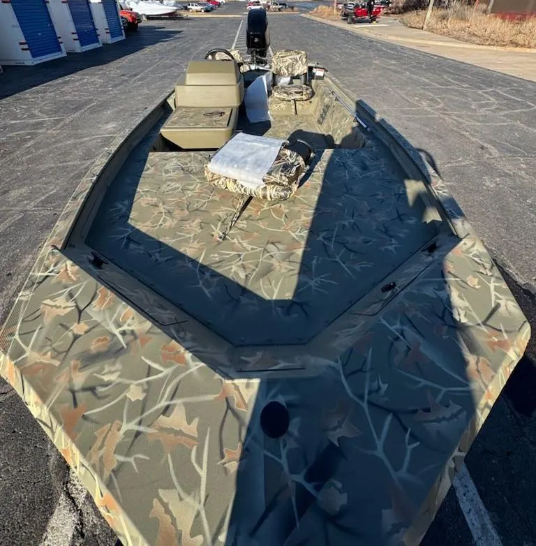 Slide: The Image of 2025 Tracker Grizzly 1754 SC boat with camouflage design on a paved surface. - 33
