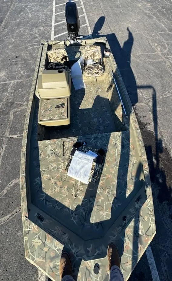 Slide: The Image of 2025 Tracker Grizzly 1754 SC boat with camouflage design in a parking lot. - 34