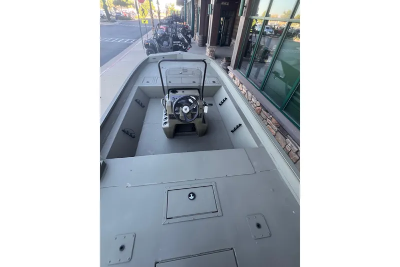Slide: The Image of 2025 Tracker Grizzly 2072 CC boat, center console, parked outside a building. - 4