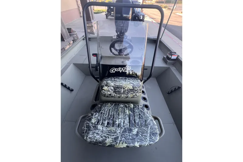 Slide: The Image of 2025 Tracker Grizzly 2072 CC boat interior with camo seats and steering console. - 6