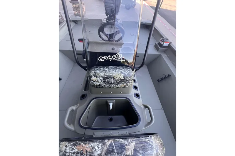 Slide: The Image of 2025 Tracker Grizzly 2072 CC boat interior with camouflage seating and steering console. - 7