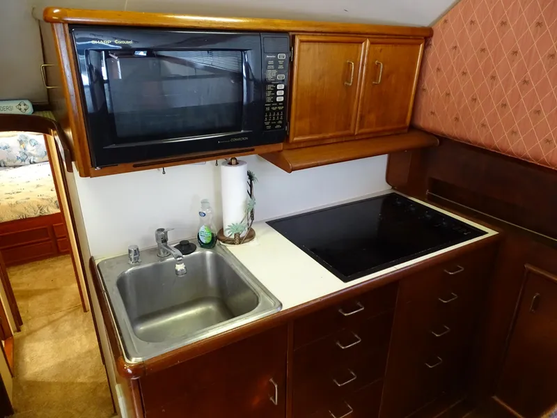 Slide: The Image of 1987 Ocean Yachts 48 kitchen with microwave, sink, and stovetop. - 16