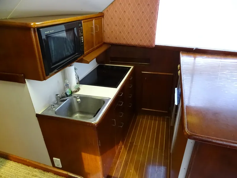 Slide: The Image of 1987 Ocean Yachts 48 galley with wood cabinetry, sink, and microwave. - 17