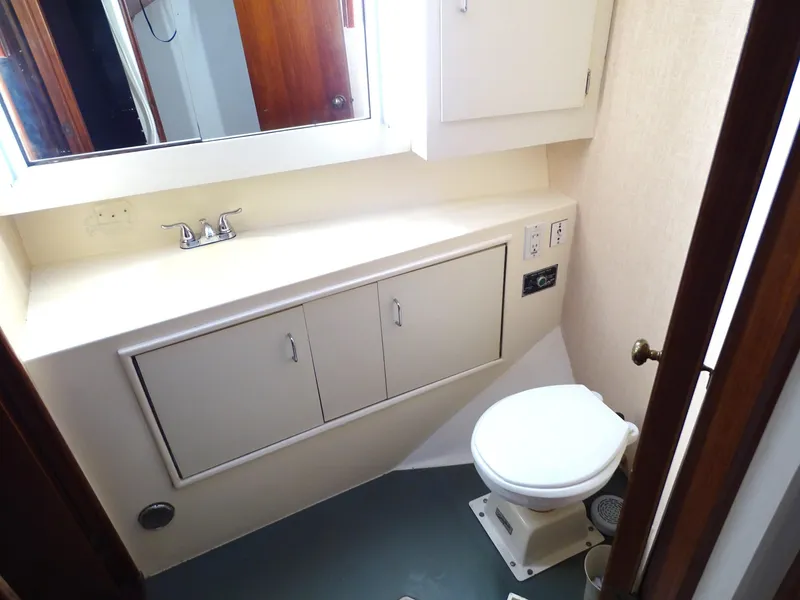 Slide: The Image of Bathroom interior of 1987 Ocean Yachts 48, featuring sink, cabinets, and toilet. - 19