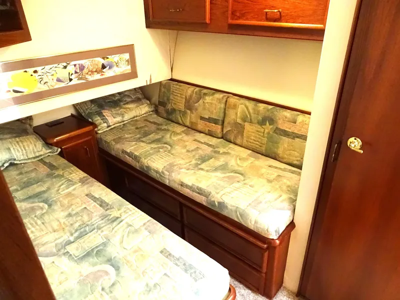 Slide: The Image of Cozy twin cabin in 1987 Ocean Yachts 48, featuring patterned bedding and wooden storage. - 20