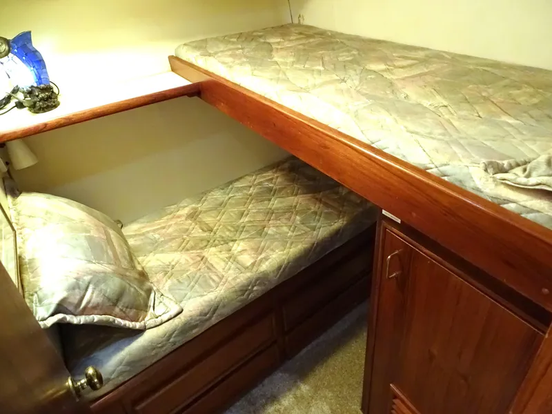 Slide: The Image of Cozy bunk beds in 1987 Ocean Yachts 48 cabin, featuring wooden accents and soft lighting. - 22