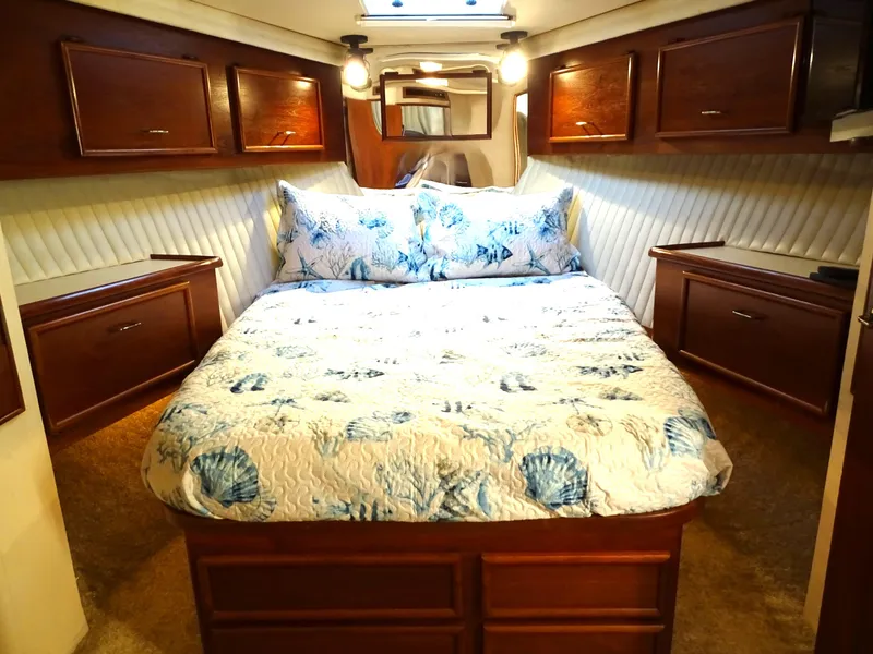 Slide: The Image of Luxurious 1987 Ocean Yachts 48 bedroom with elegant wood cabinetry and nautical bedding. - 24