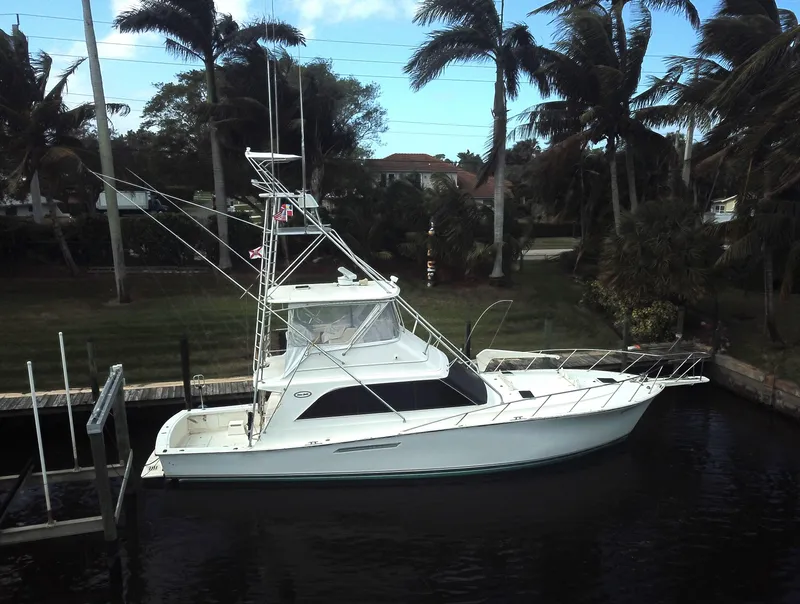 Slide: The Image of 1987 Ocean Yachts 48 docked, surrounded by palm trees and calm waters. - 3