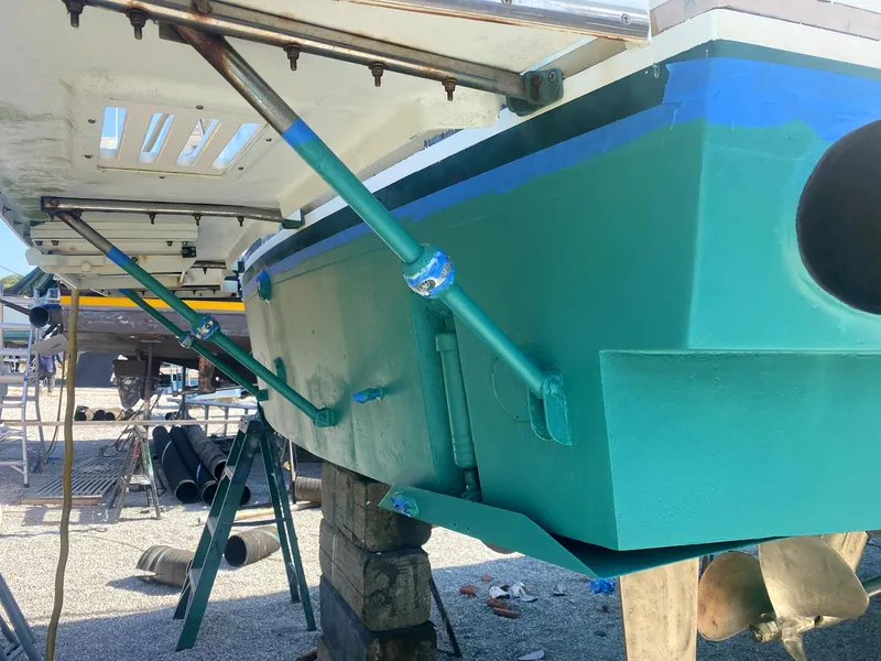 Slide: The Image of 1987 Ocean Yachts 48 boat hull in dry dock, showing green paint and support structures. - 37