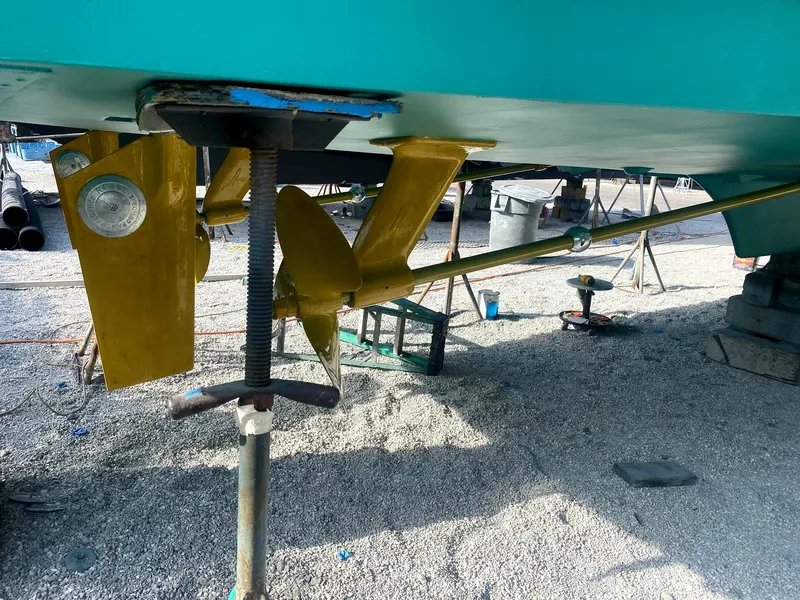 Slide: The Image of 1987 Ocean Yachts 48 underbody with propeller and rudder, displayed on gravel. - 40