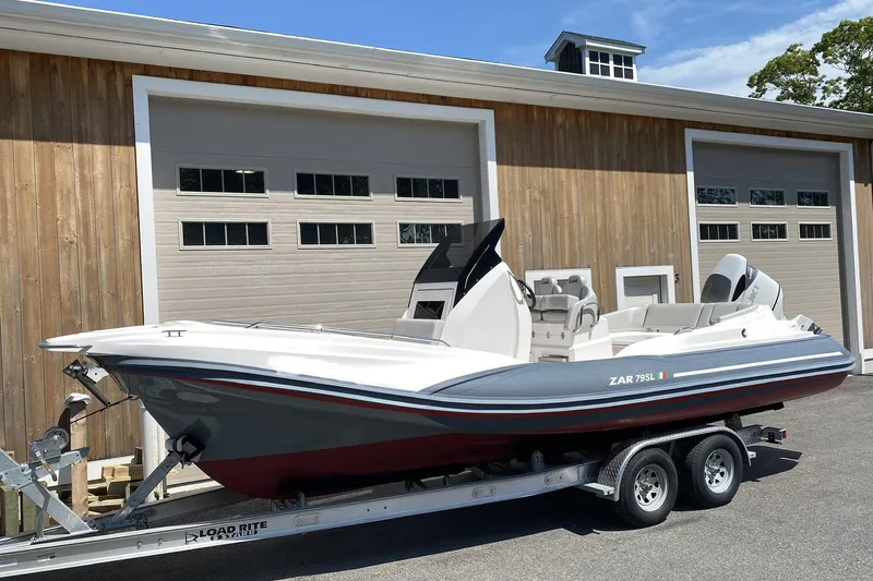 Slide: The Image of 2022 Zar Formenti Zar 79 boat with outboard motor on a trailer, surrounded by trees. - 4
