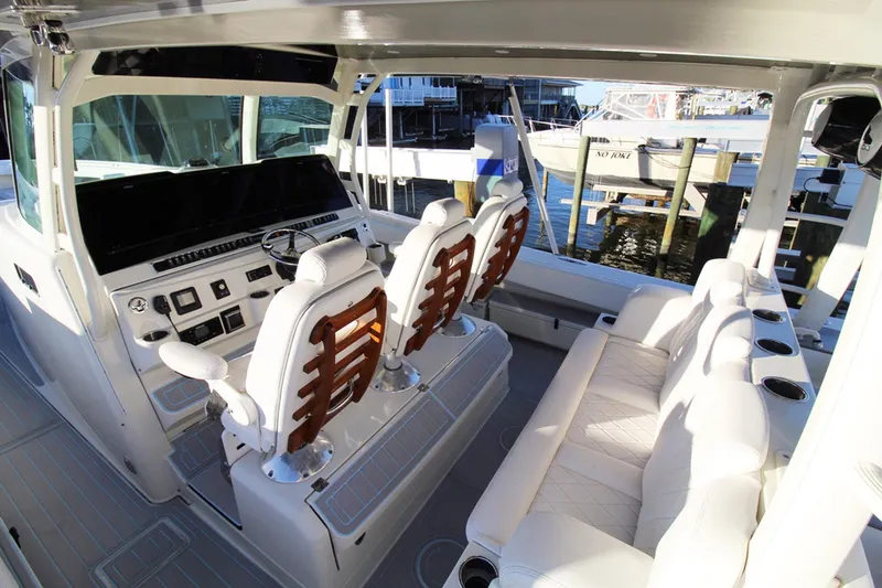 Slide: The Image of 2017 HCB Suenos boat interior with luxurious seating and modern dashboard at a marina. - 15