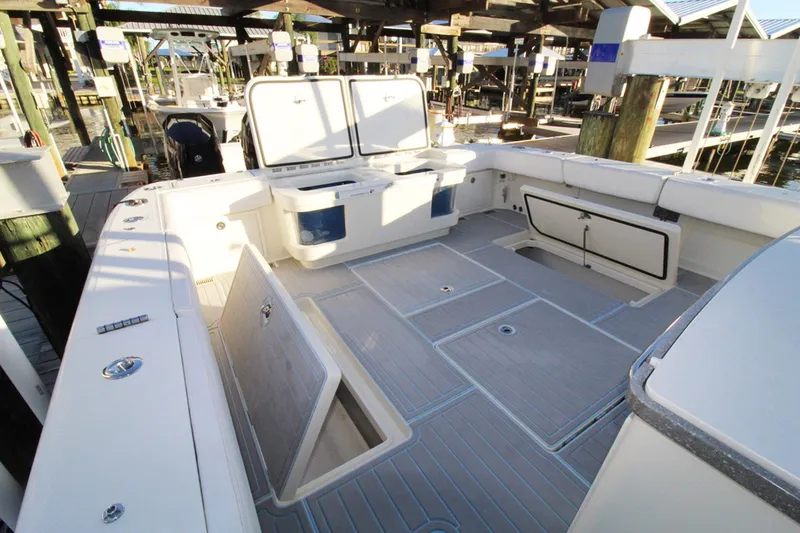 Slide: The Image of 2017 HCB Suenos boat deck with storage compartments and seating at a marina. - 7