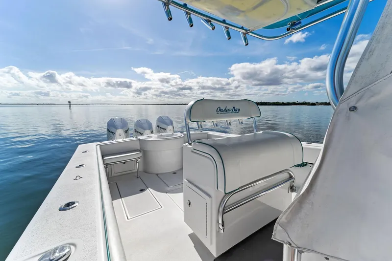 Slide: The Image of 2018 Onslow Bay 33 Tournament boat on calm water, featuring sleek design and triple engines. - 27
