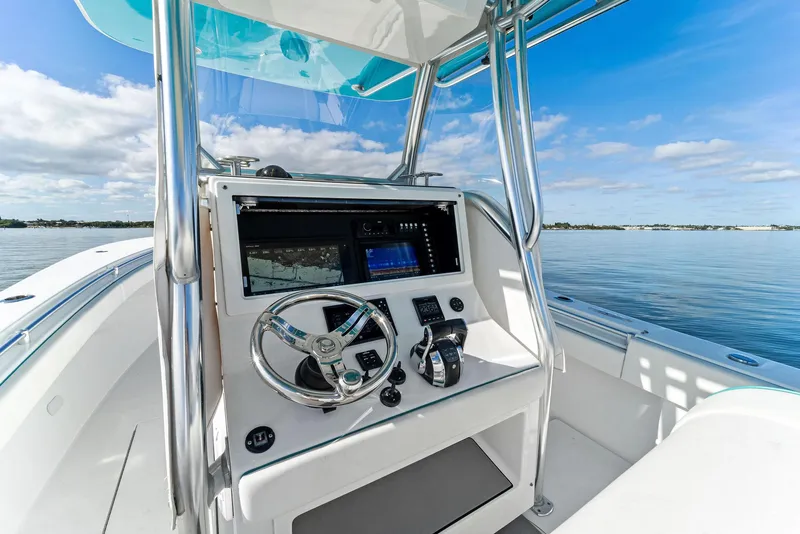 Slide: The Image of 2018 Onslow Bay 33 Tournament boat console with steering wheel and controls on open water. - 38